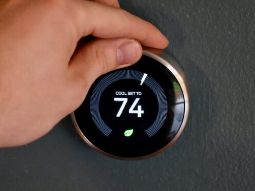 Person adjusting the thermostat